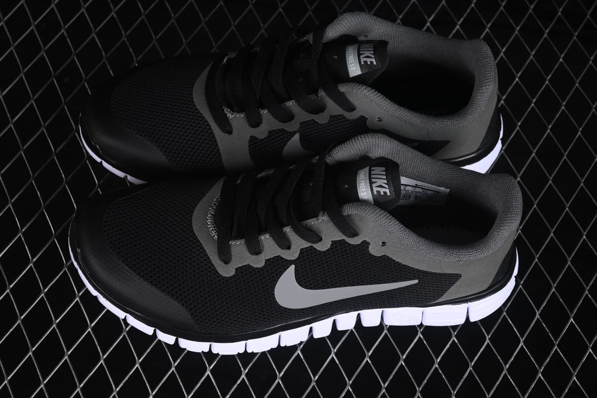 Angled top view of the pair displaying the black mesh uppers, grey overlays and side Swoosh logos.