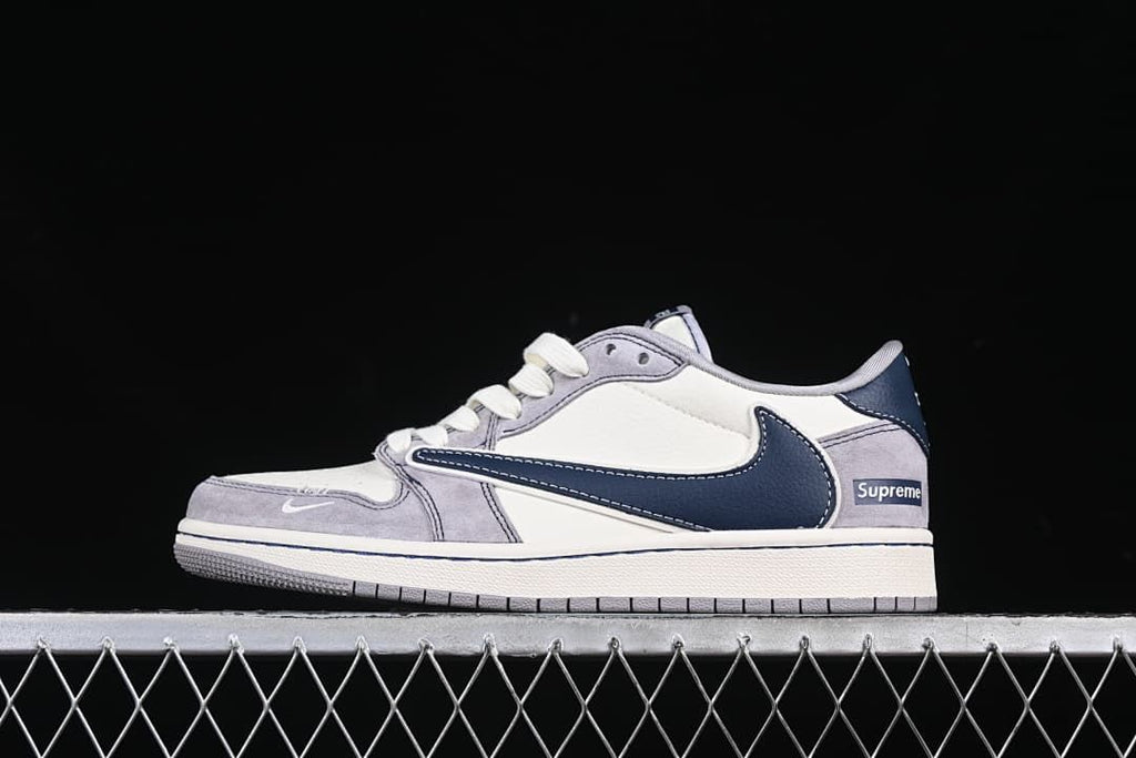 Side view of a light grey, off-white, and navy low-top sneaker