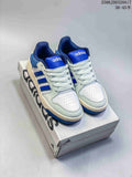 Pair of white and royal-blue adidas Entrap sneakers displayed on a shoebox