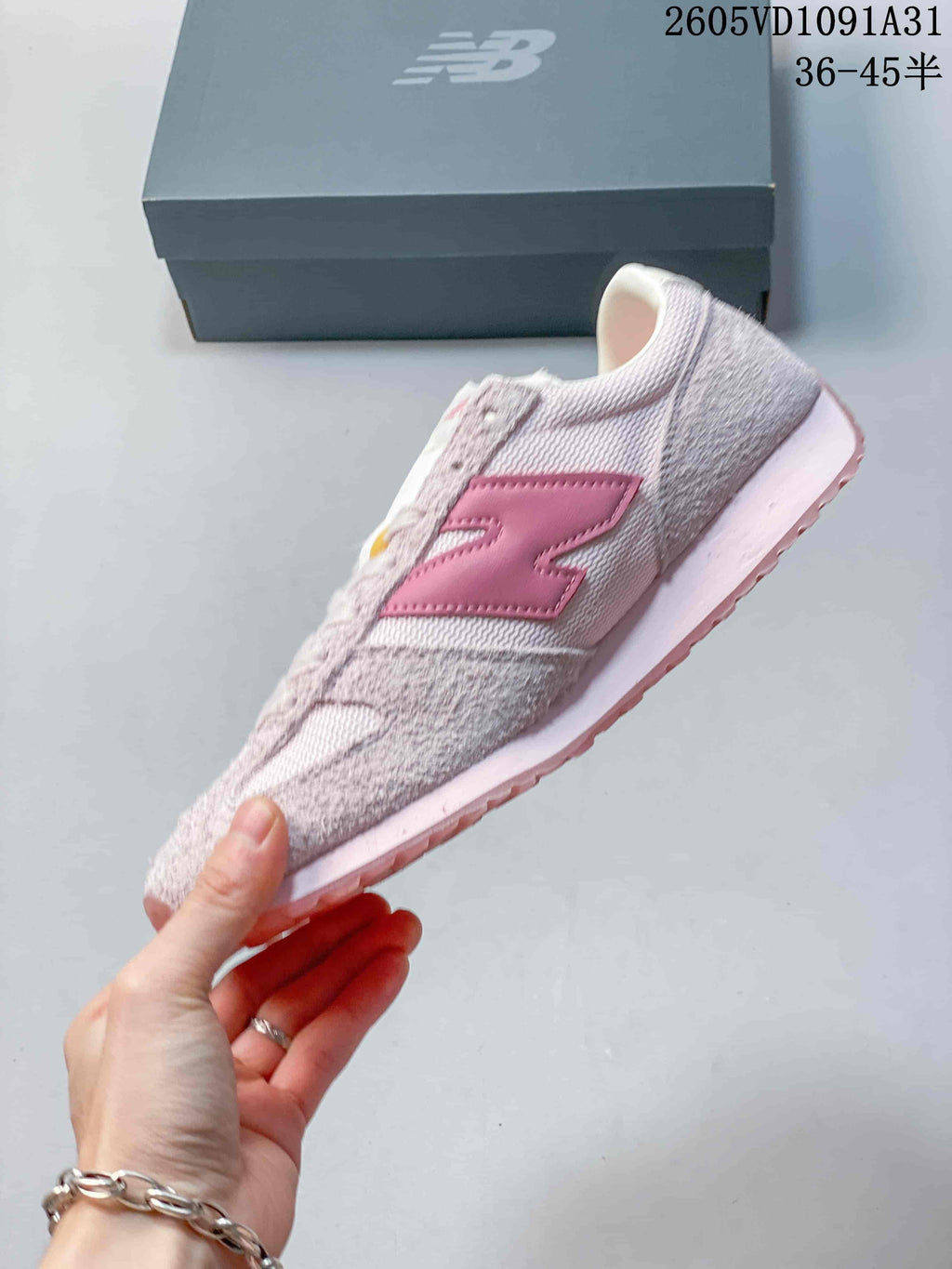 Side profile of a pale pink New Balance 471 sneaker with a darker pink logo.