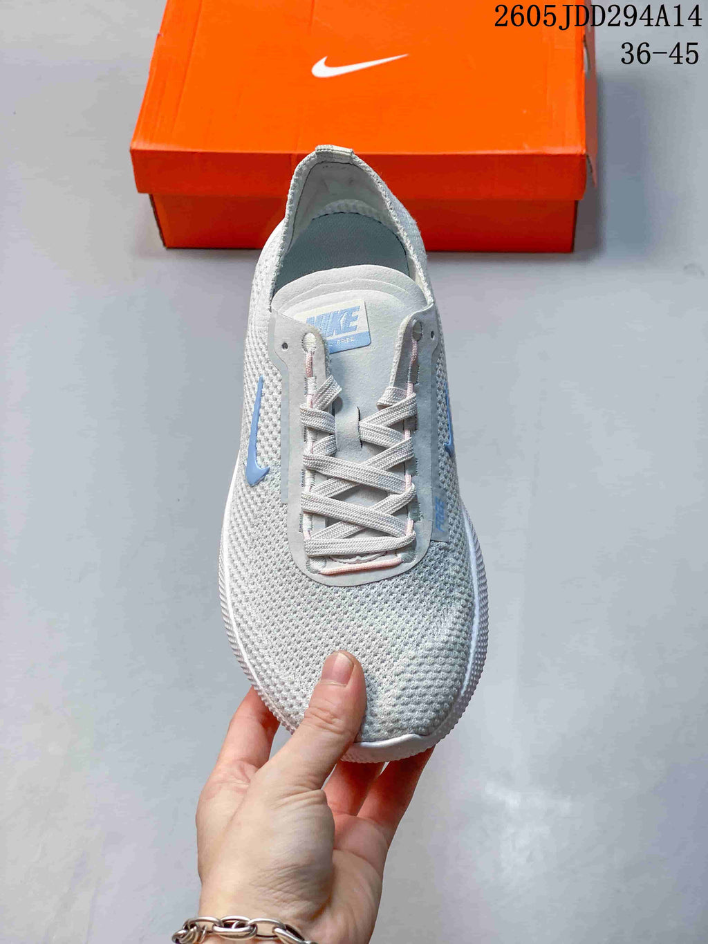 Top view of the lace-up front and knit-look upper of a light gray Nike Free shoe