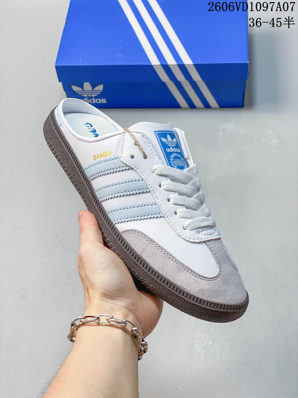 Angled side view of a white and light blue adidas Samba OG mule with open heel