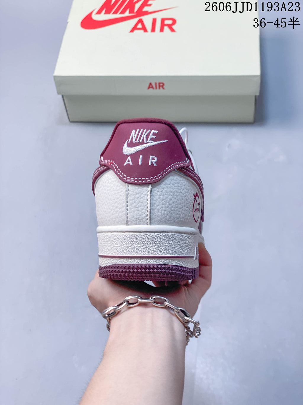 Rear view showing the burgundy heel tab and white upper.