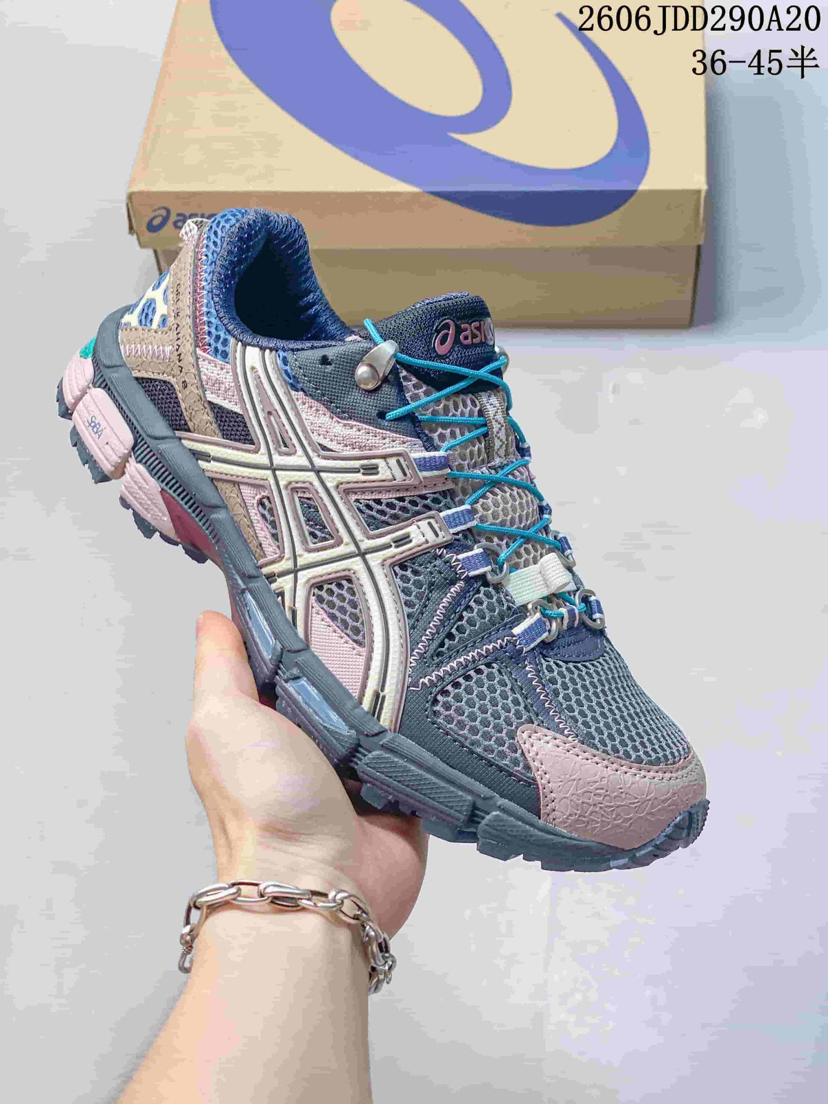 Angled side view of a gray and pink ASICS Gel-Kahana 8 shoe on a shoe box.