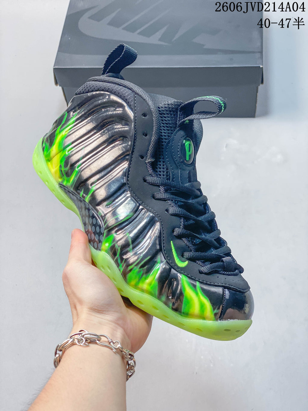Angled close-up of the gray sculpted upper with bright green details and a translucent-looking outsole.