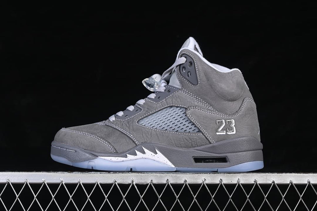 Side view of a grey and white Air Jordan 5 high-top sneaker