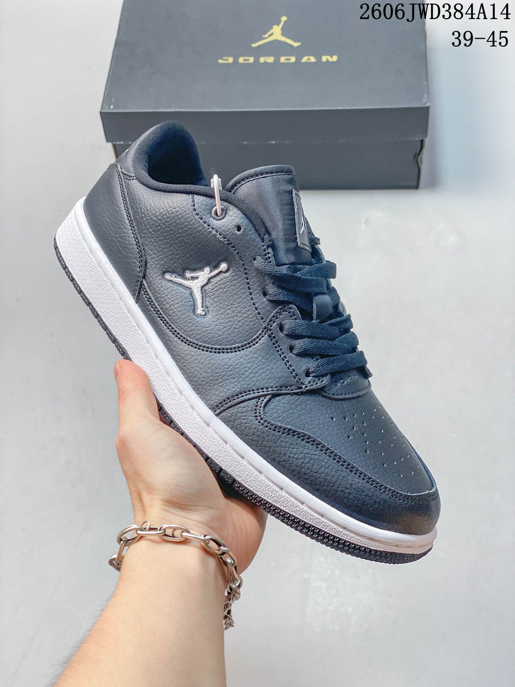 Side and upper view of a dark grey Jordan sneaker with white Jumpman detail