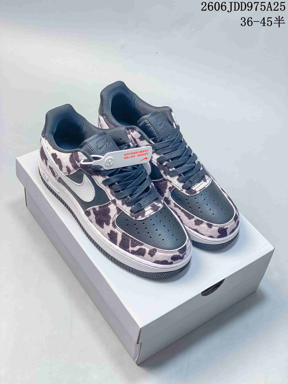 Pair of dark Nike Air Force 1 sneakers with a cow-print overlay and white Swoosh.