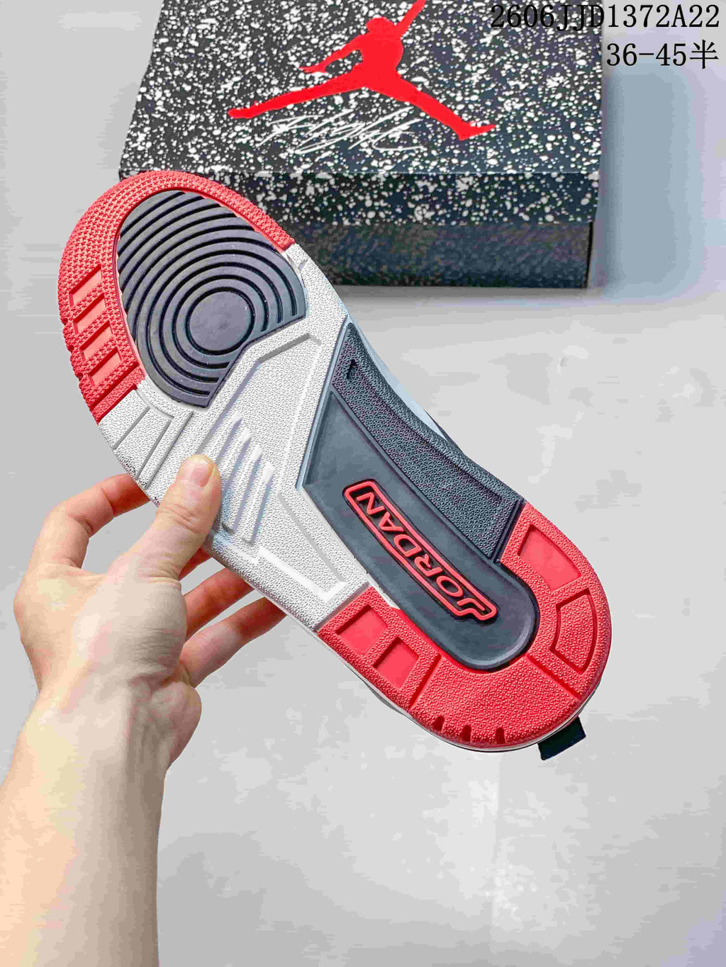 Outsole view showing charcoal, white, and red sections on a Jordan Spizike Low sneaker