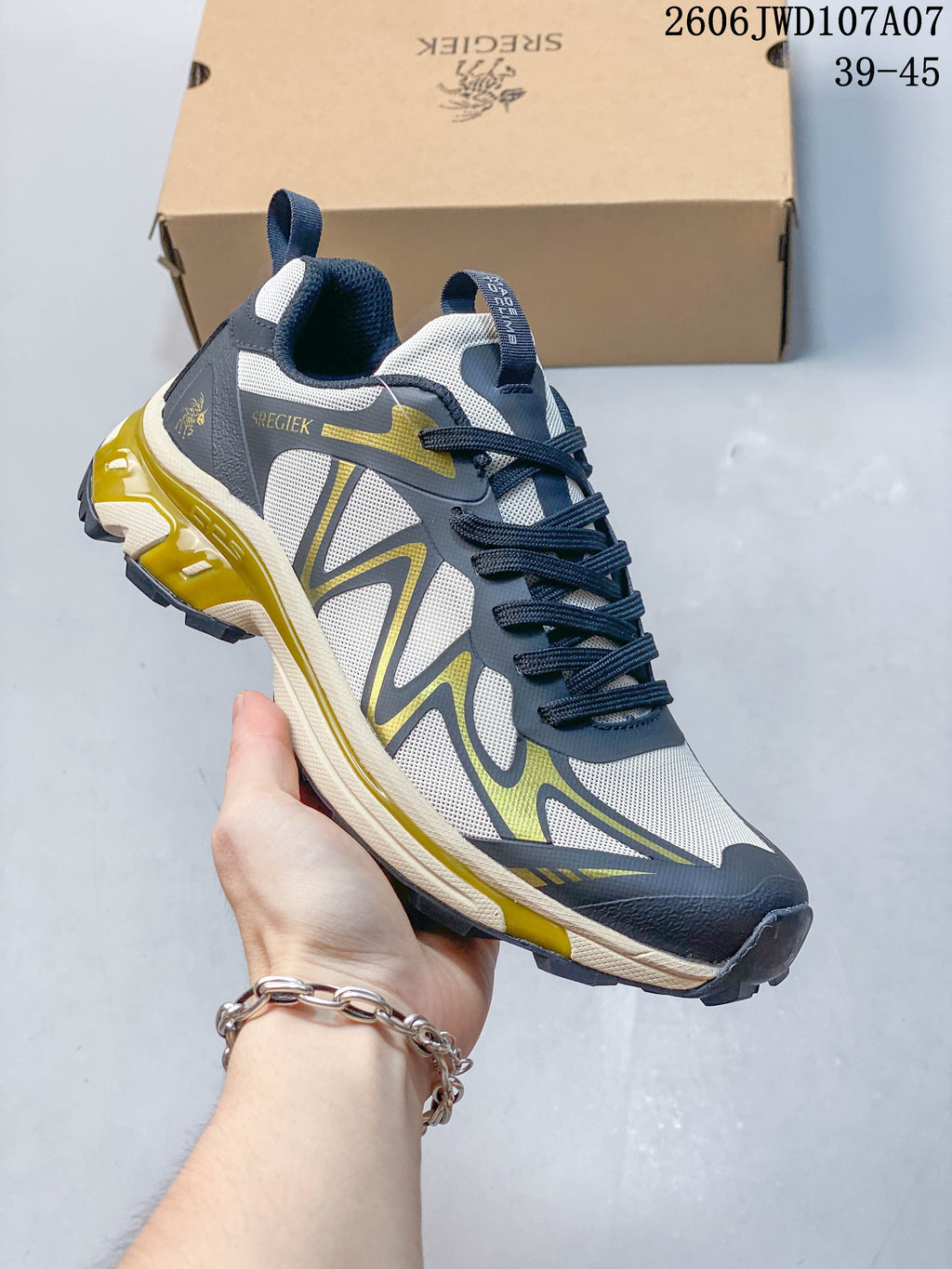 Angled view of the Sregiek hiking shoe in gray, dark gray, and olive; image overlay shows style code 2606JWD107A07 and size range 39–45.