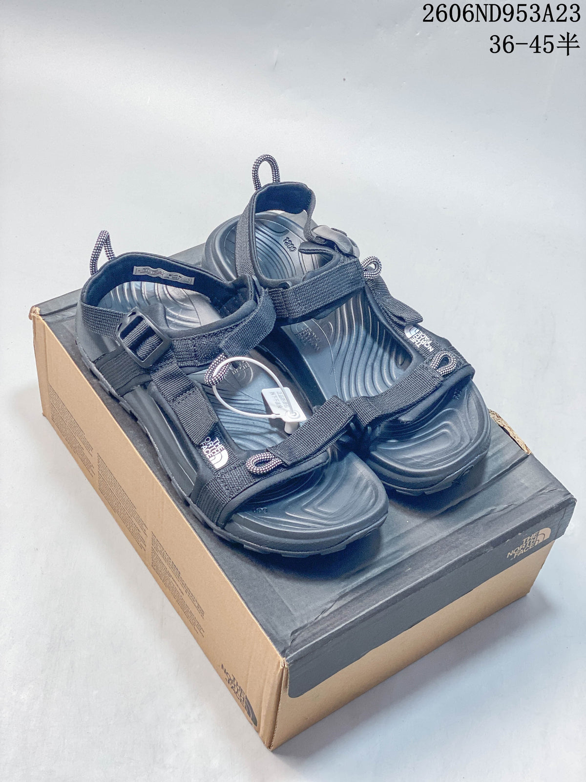 Pair of dark gray-black The North Face Explore Camp sandals displayed on a shoe box