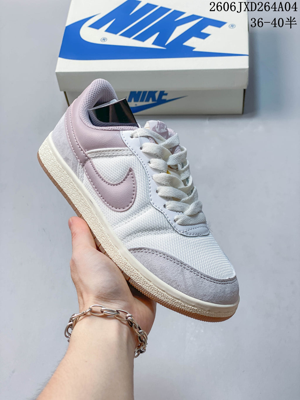White low-top sneaker with pale pink and gray accents