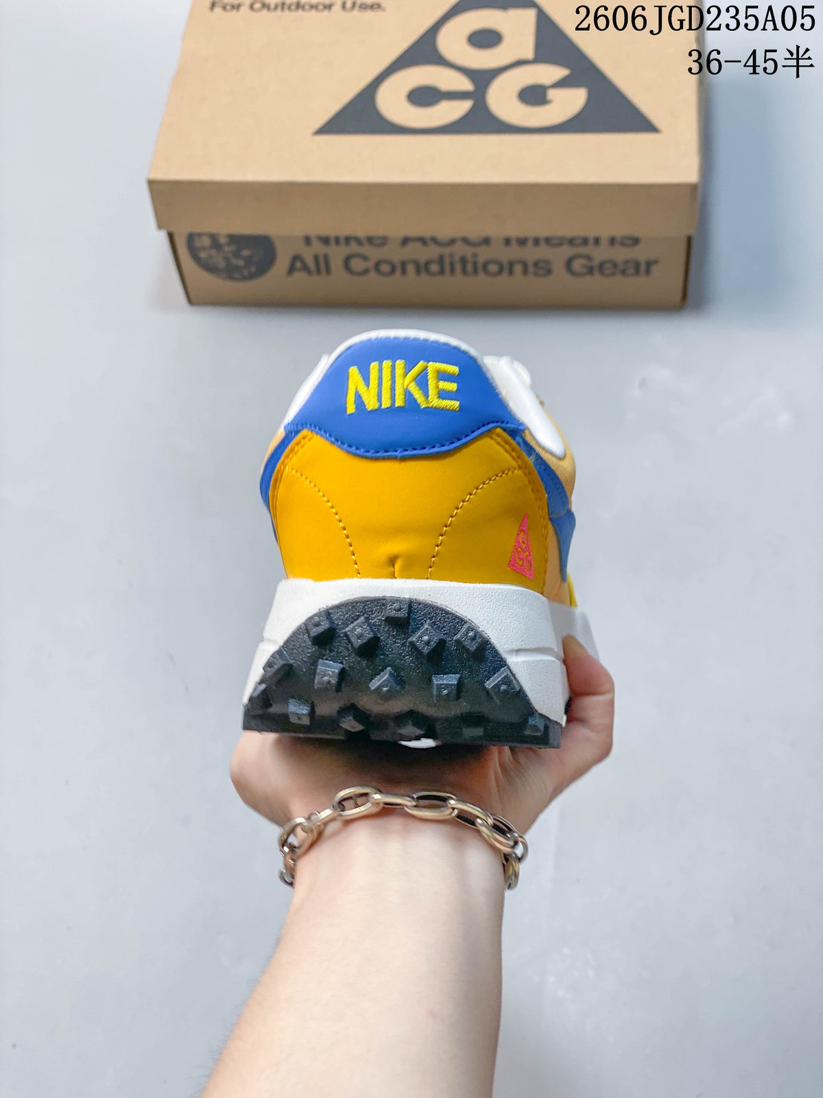 Rear view of the yellow and blue shoe with a lugged outsole