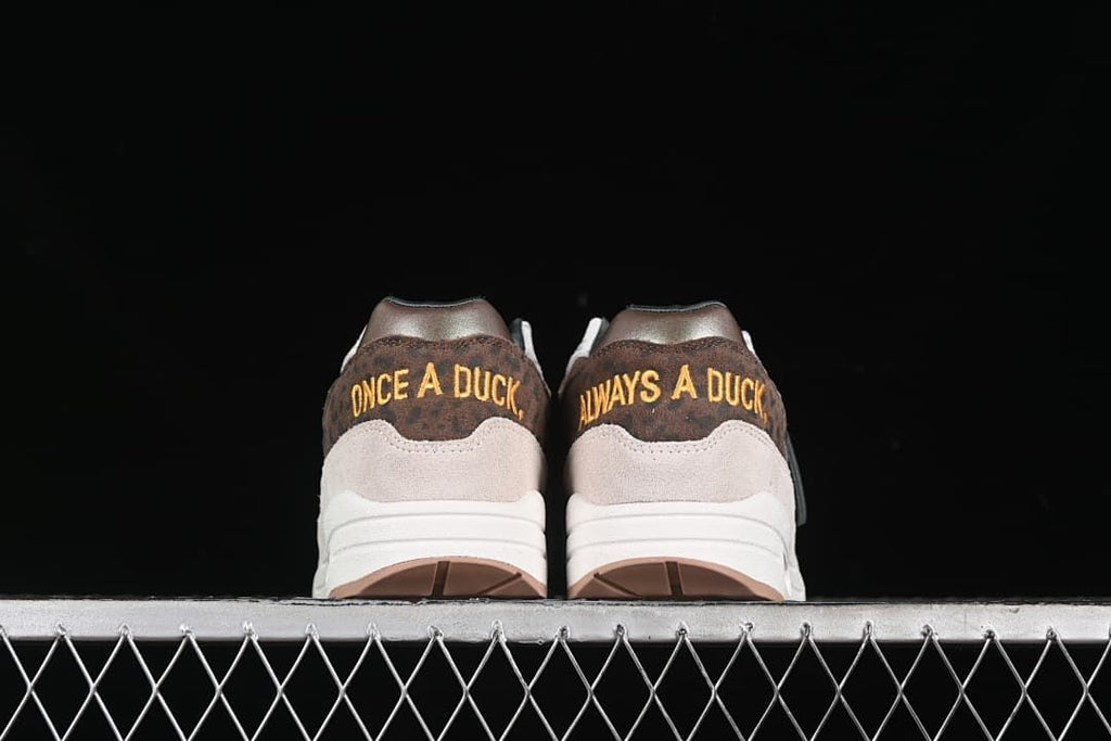Rear view showing embroidered heel phrases on both shoes