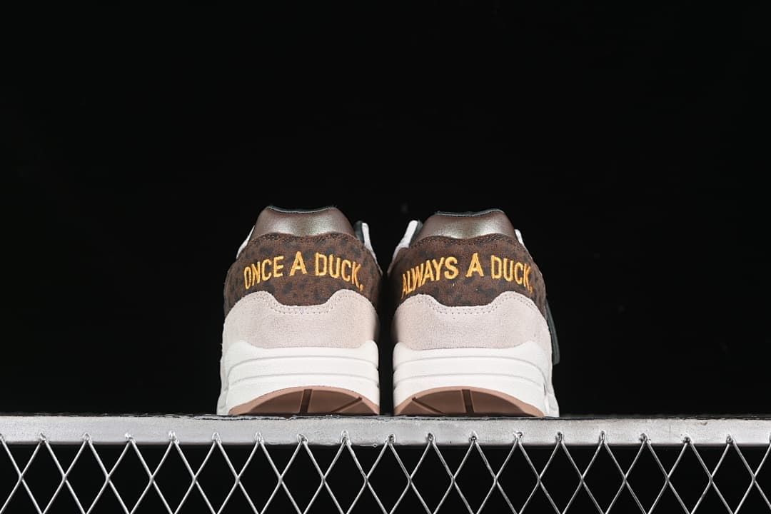 Rear view showing embroidered heel phrases on both shoes