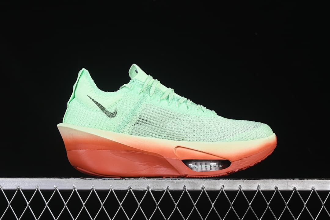 Side profile showing the mint-green upper, dark Swoosh and coral-orange sole.