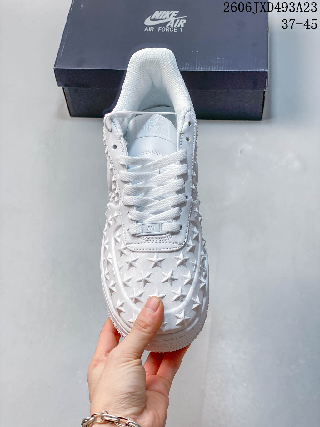 Top view of the white sneaker showing the laces and raised star detailing