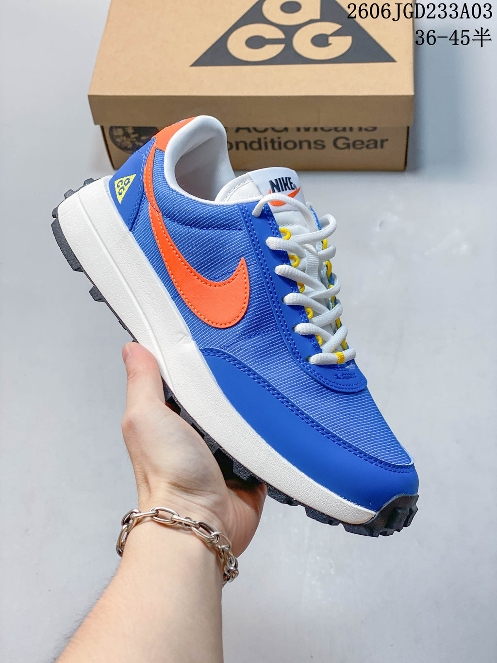 Side view highlighting the blue upper, orange Swoosh, and dark lugged outsole
