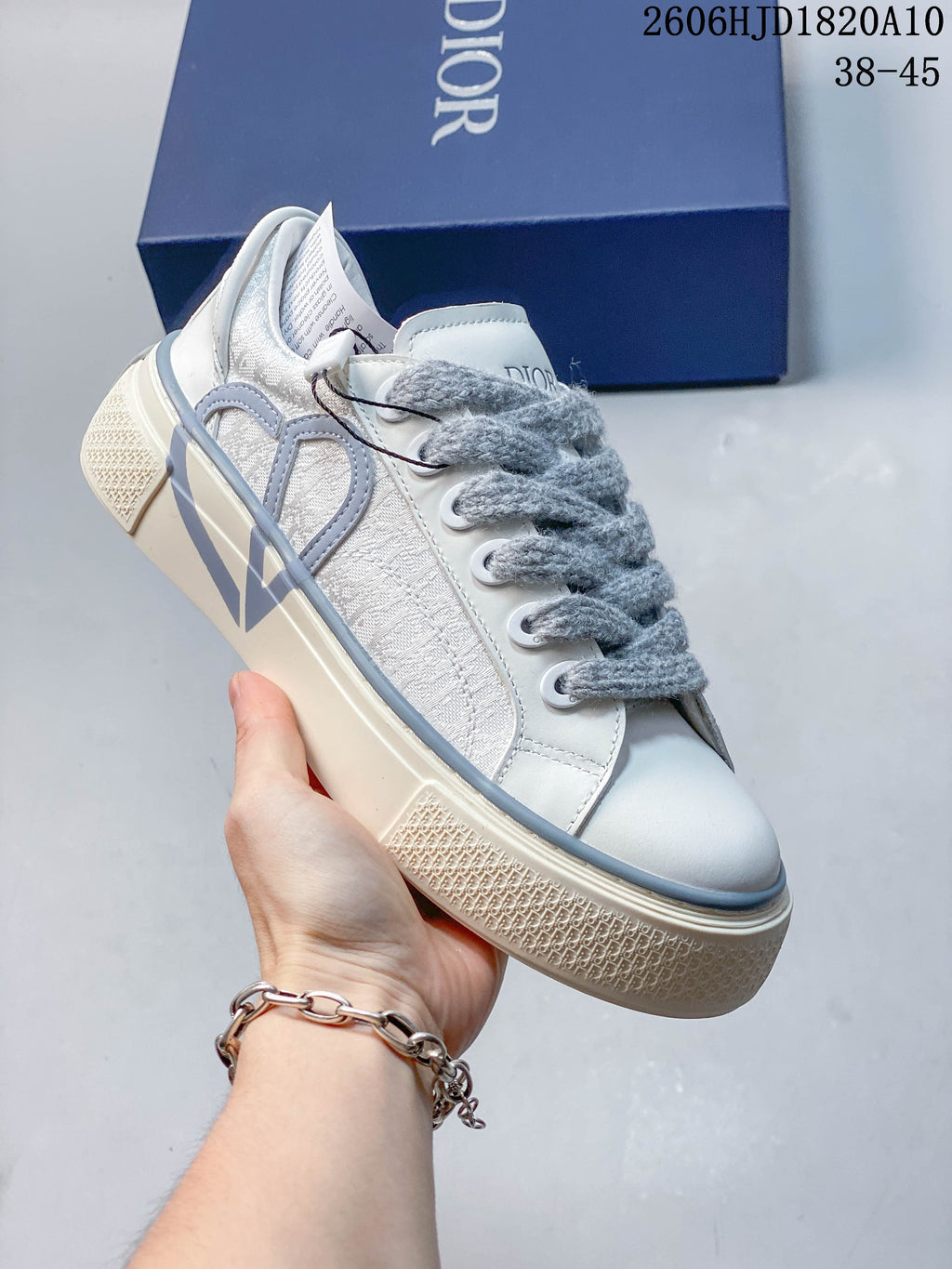 Angled side view of a white and gray Dior B33 sneaker with patterned panels and a chunky sole