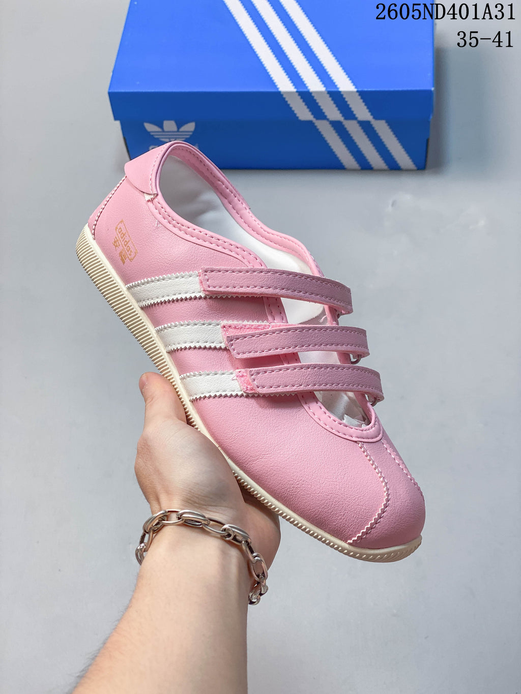 Side view of the pink low-top sneaker with white stripes and an off-white sole