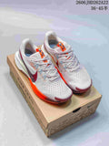 Pair of pale pink and white Nike Pegasus Trail 5 shoes with orange and burgundy accents, shown on a Nike Trail box