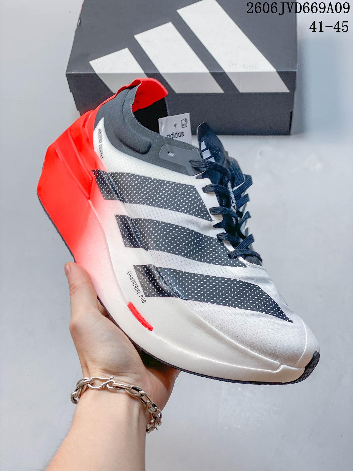 Side view showing the white upper, dark stripes, and bright red heel