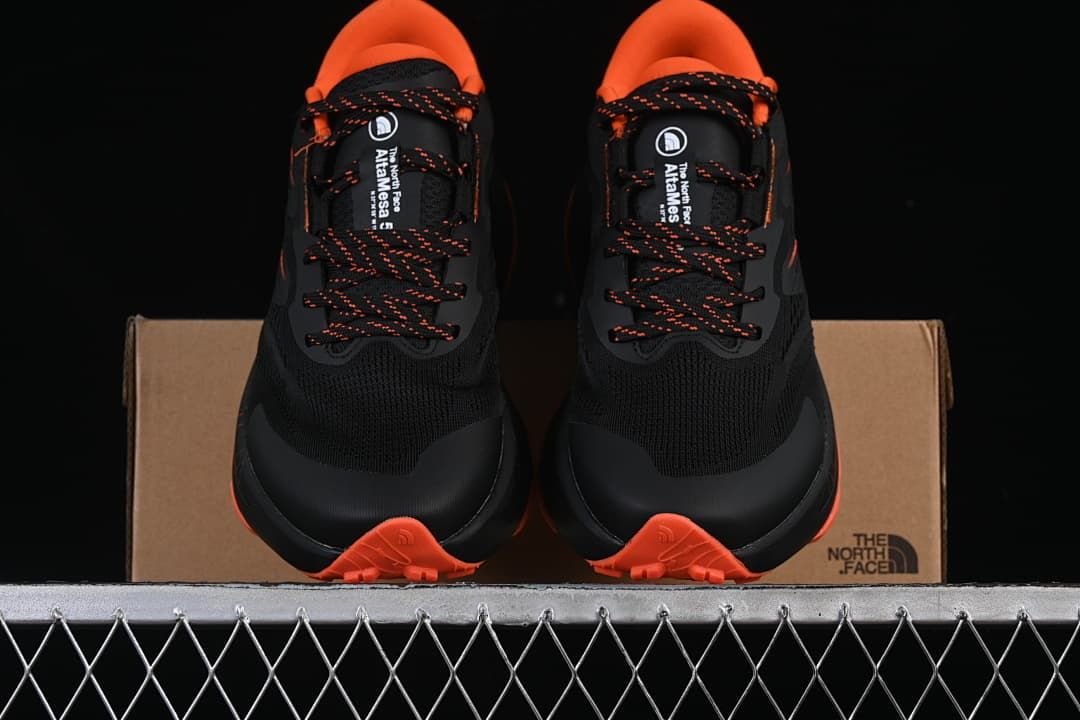 Front view of the pair, showing the black uppers and orange soles.