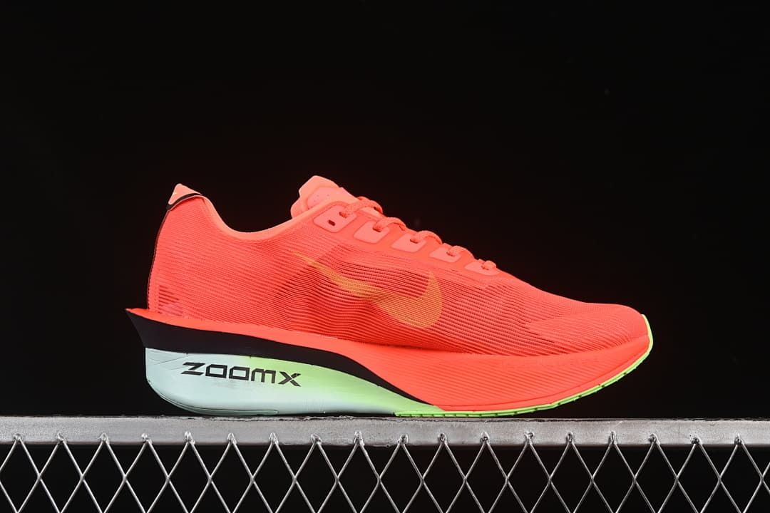 Side profile showing the coral upper, yellow swoosh and pale mint-toned midsole.