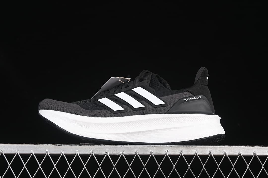 Side view of a black Adidas Ultraboost 5 shoe with white stripes and a white midsole