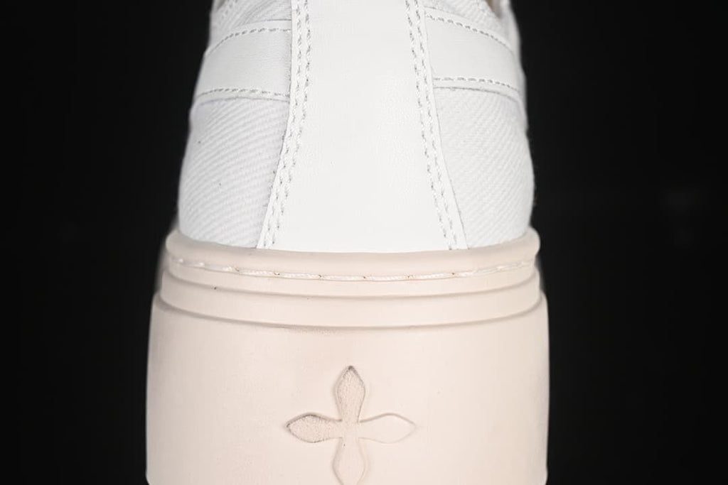 Rear close-up of the sneaker showing the heel panel and four-petal sole motif.