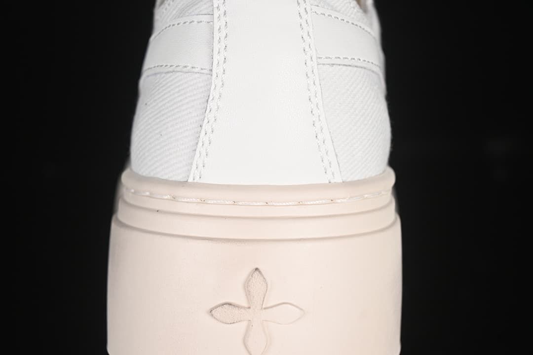 Rear close-up of the sneaker showing the heel panel and four-petal sole motif.