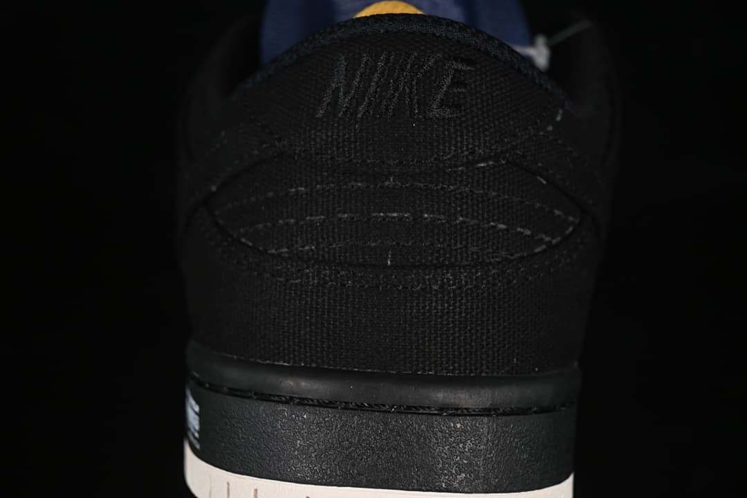 Rear view of the black sneaker heel and light-colored outsole