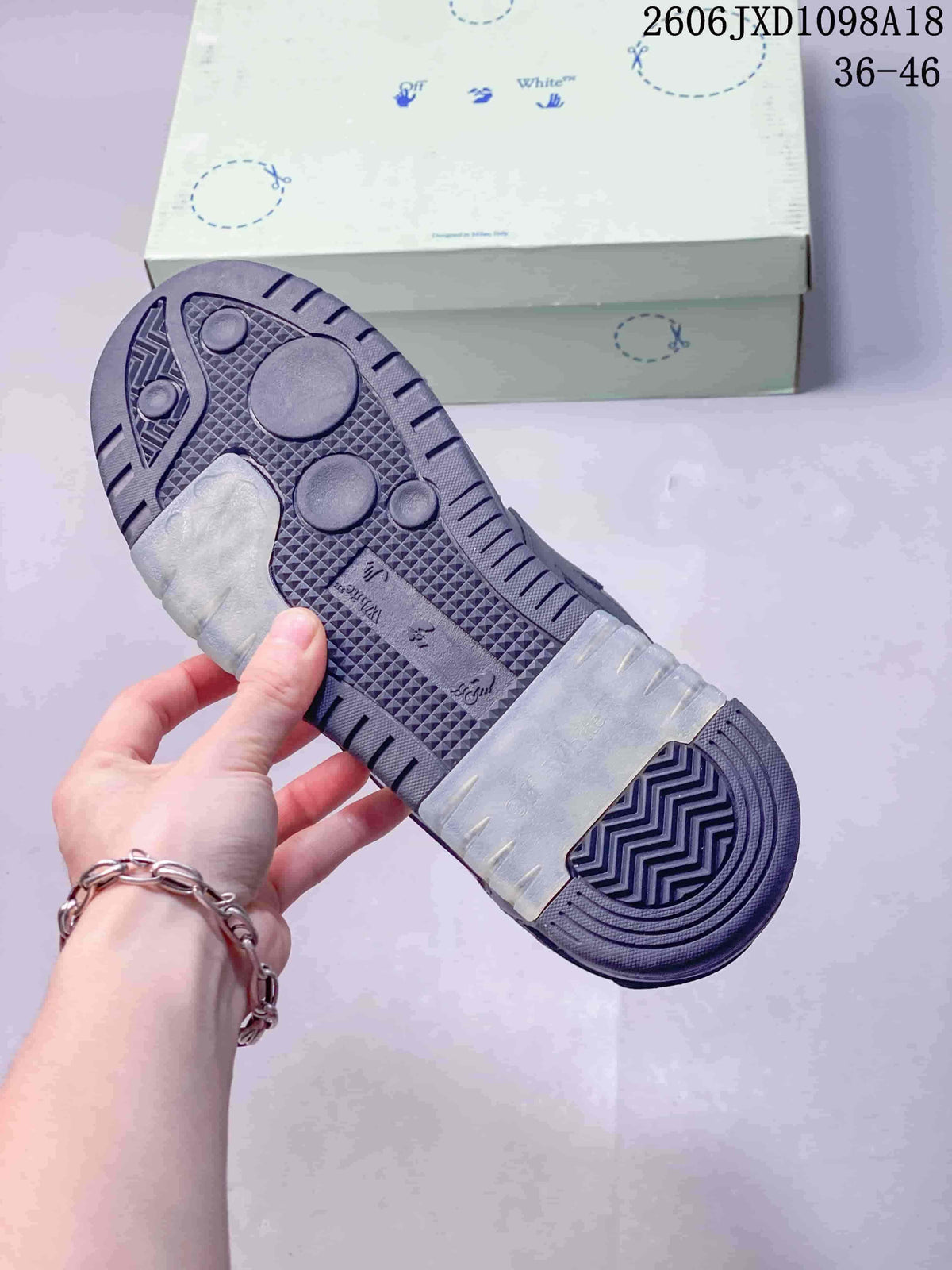 Underside of a sneaker showing a patterned dark sole with translucent sections
