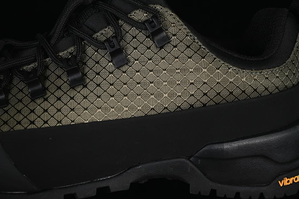Close-up of the patterned upper, lace hooks, and treaded sole