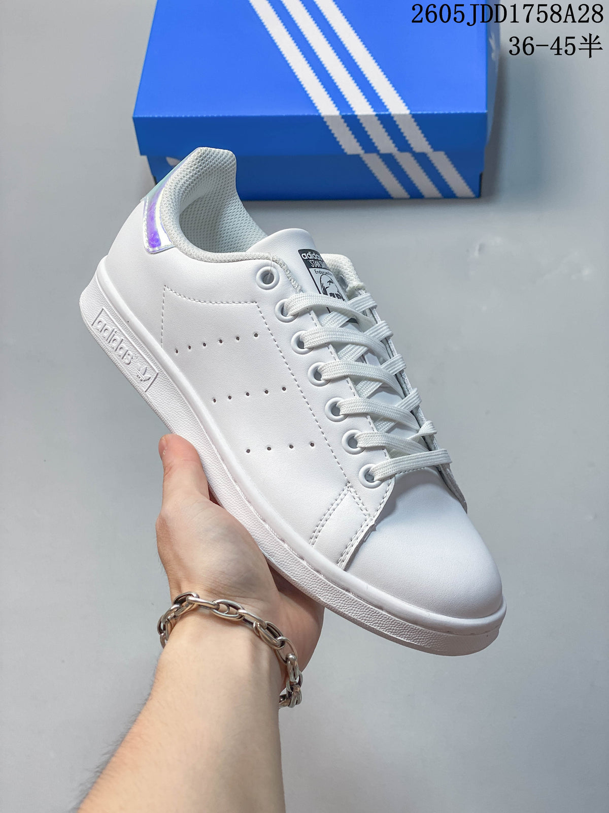 Angled view of the white low-top sneaker with perforated side panels