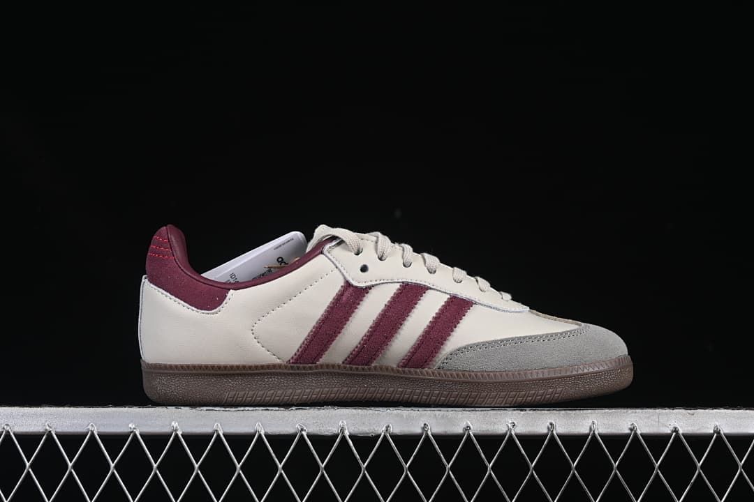 Side profile of the cream sneaker with burgundy stripes and gray toe overlay.