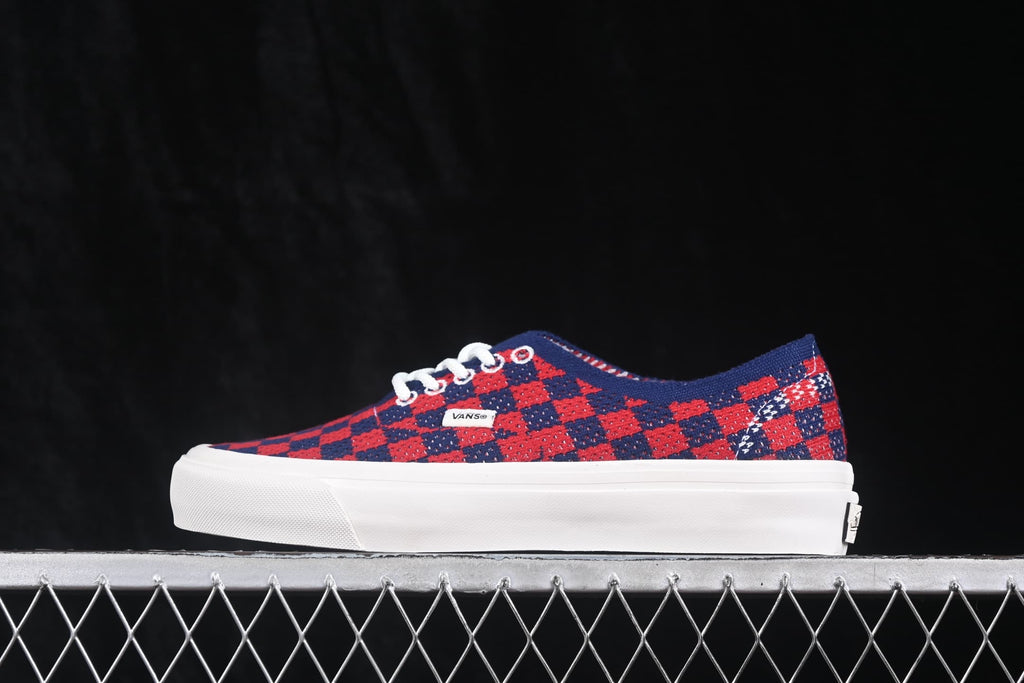 Side profile of a red and navy check-pattern sneaker with white laces and a white sole.