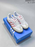 Pair of white Adidas sneakers with pink stripes and pale toe panels, displayed on a blue shoe box