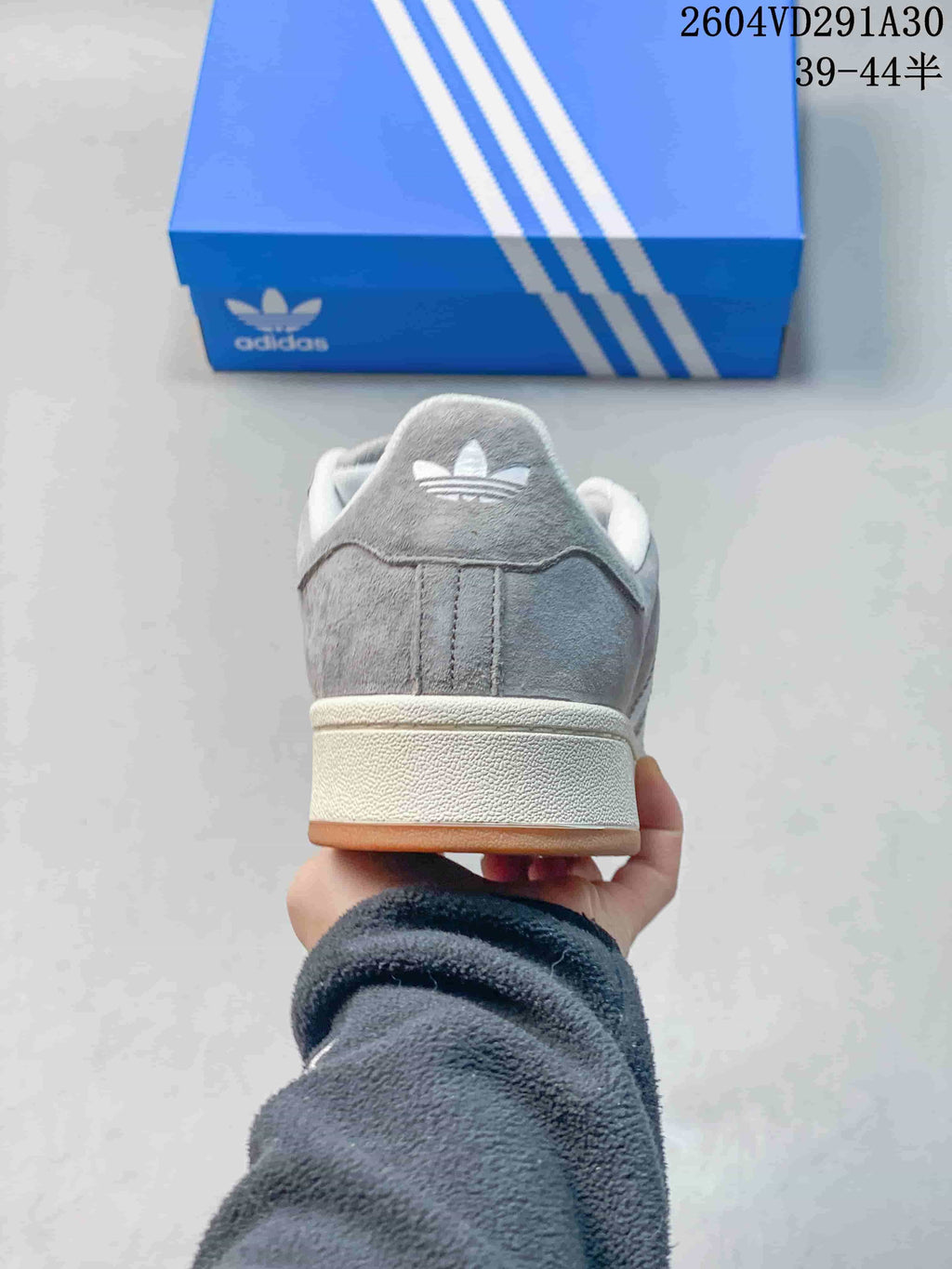 Rear view of a grey sneaker with an off-white midsole