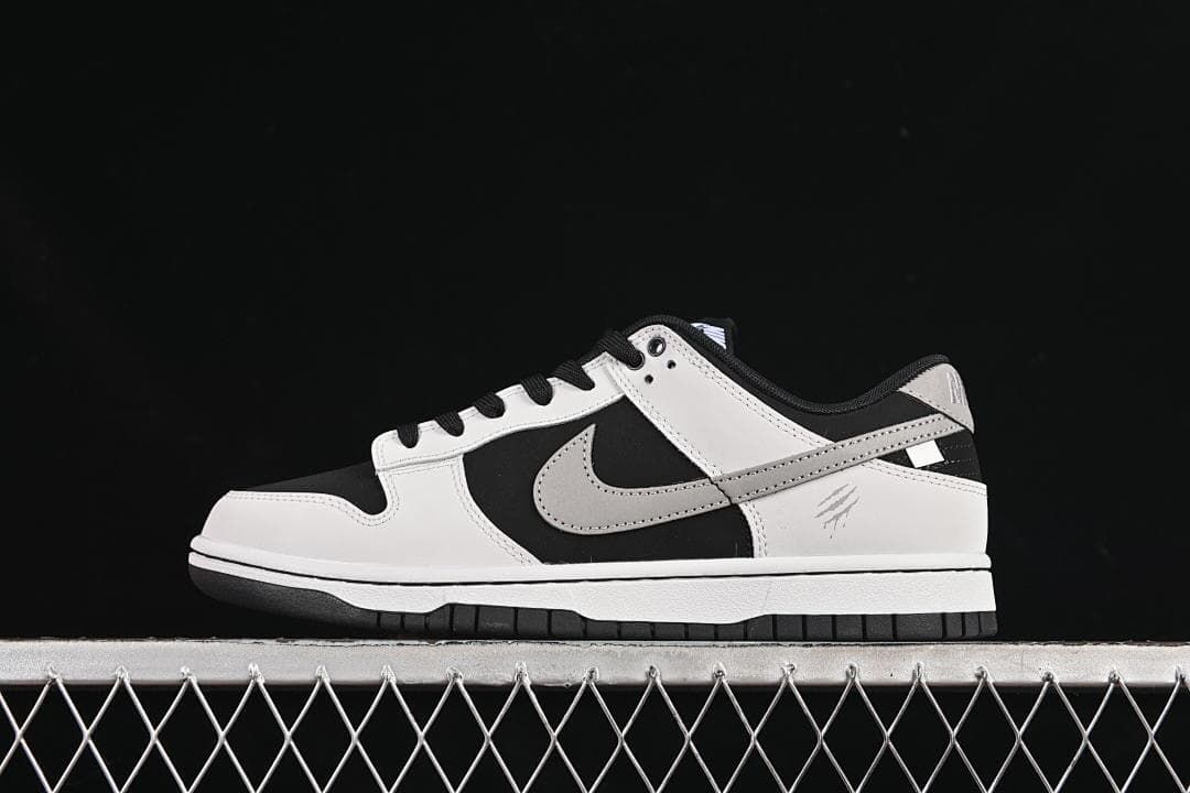 Side profile of a black, white, and grey Nike SB Dunk Low sneaker
