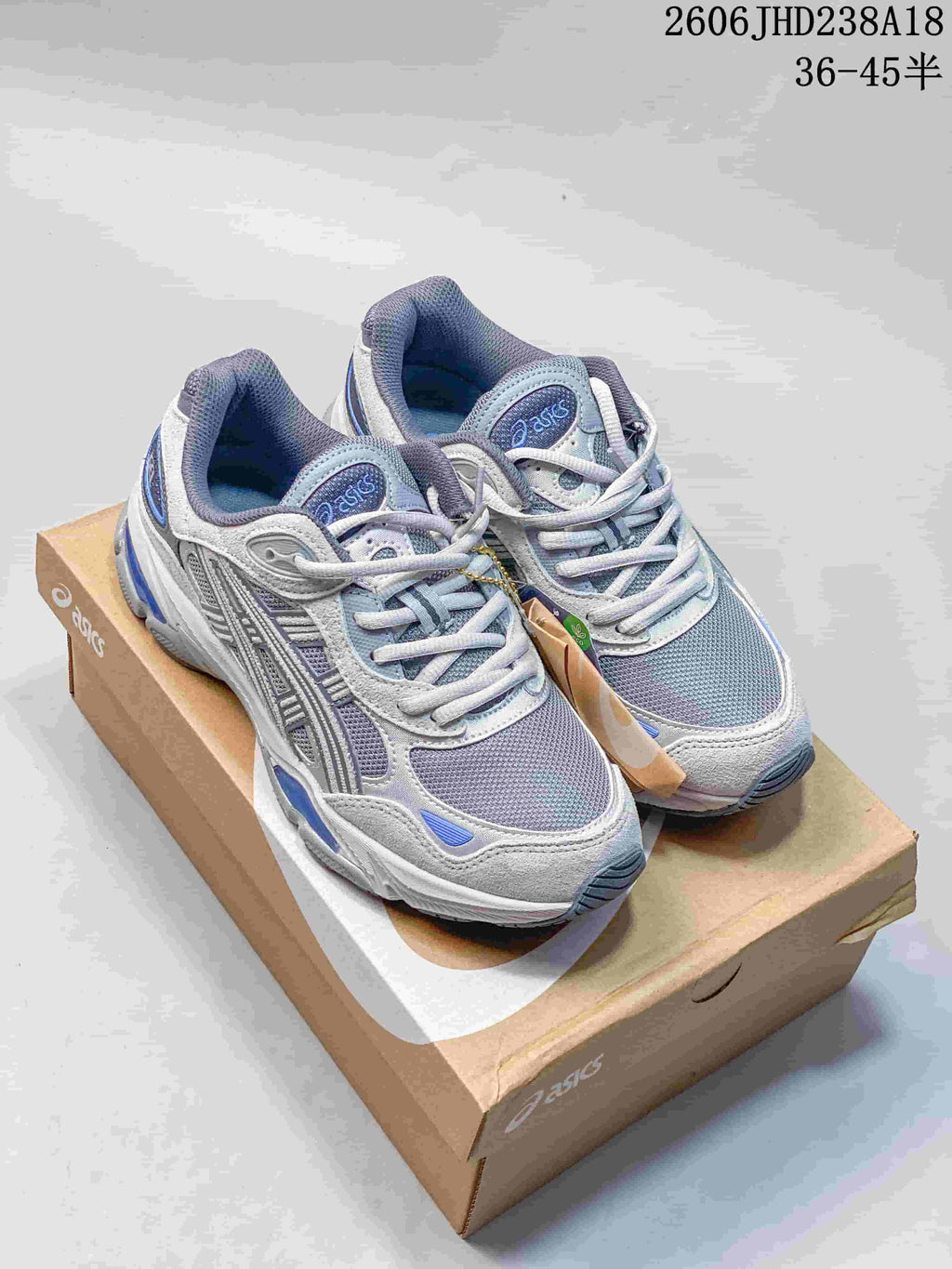 Pair of grey and blue ASICS GEL-NYC 2.0 sneakers on a shoebox