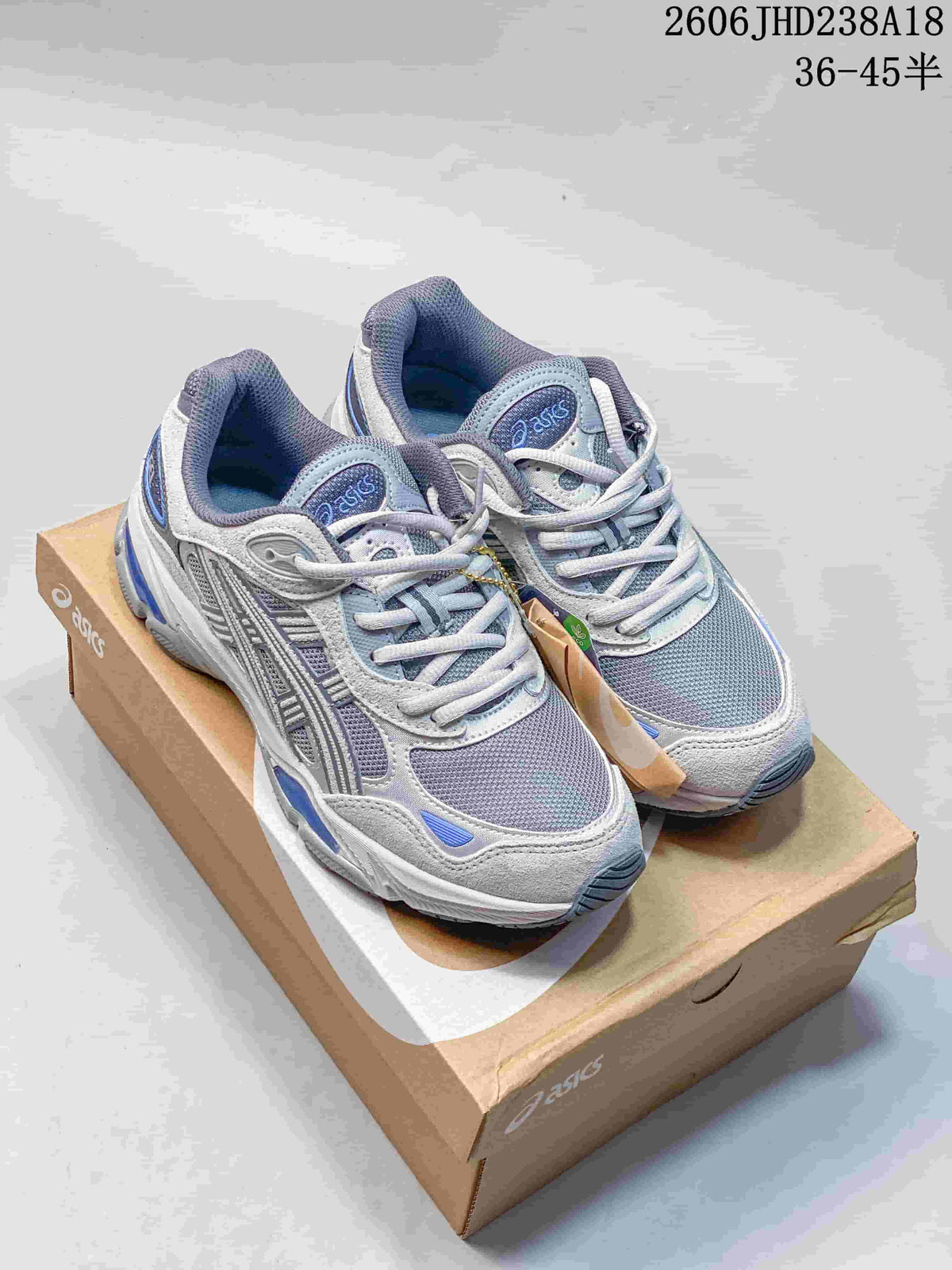 Pair of grey and blue ASICS GEL-NYC 2.0 sneakers on a shoebox