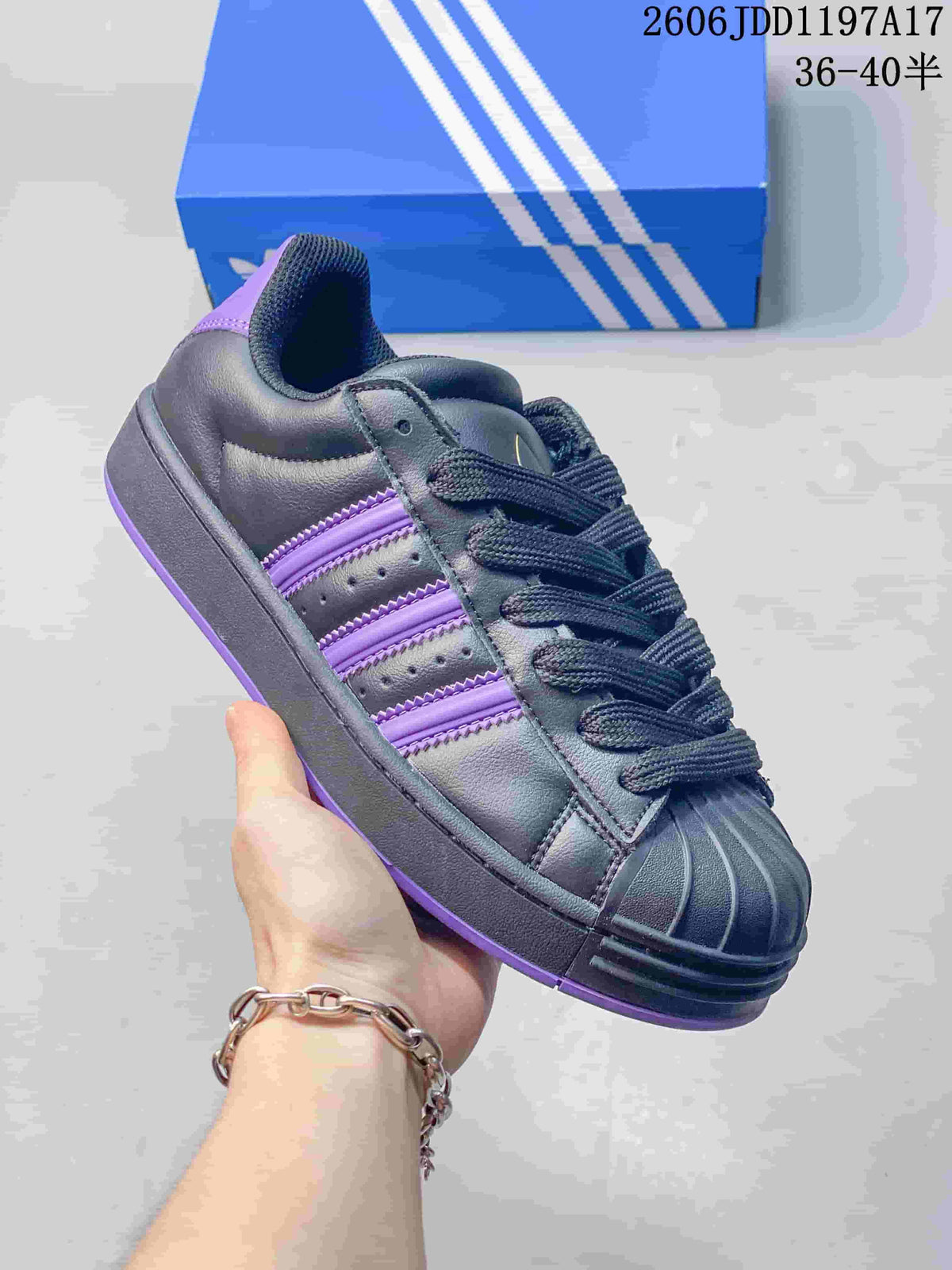 Angled side view of an adidas Superstar ST sneaker with purple side stripes and heel accents
