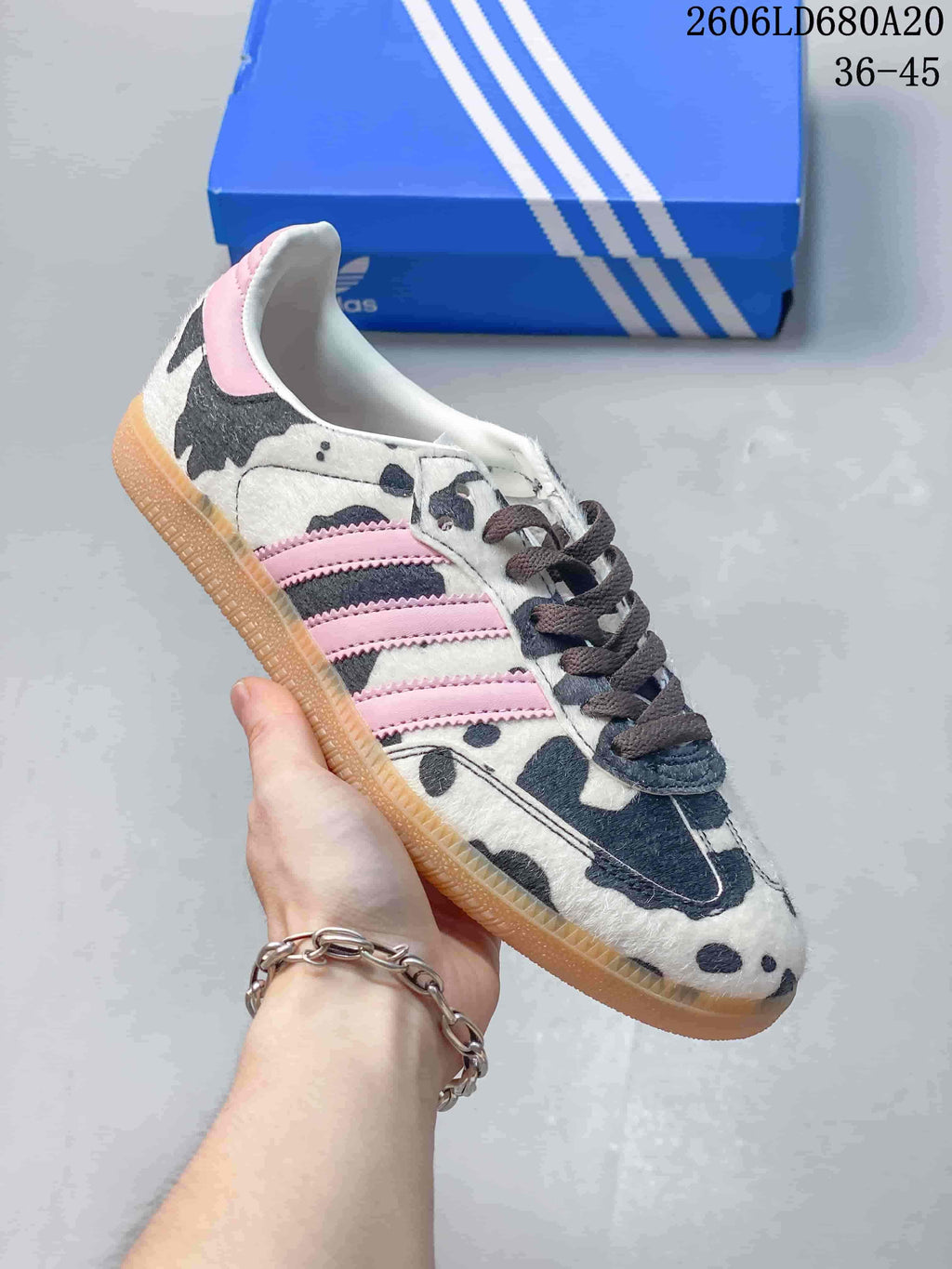Angled side view of the cow-print Adidas Samba OG with pink stripes and gum-colored outsole