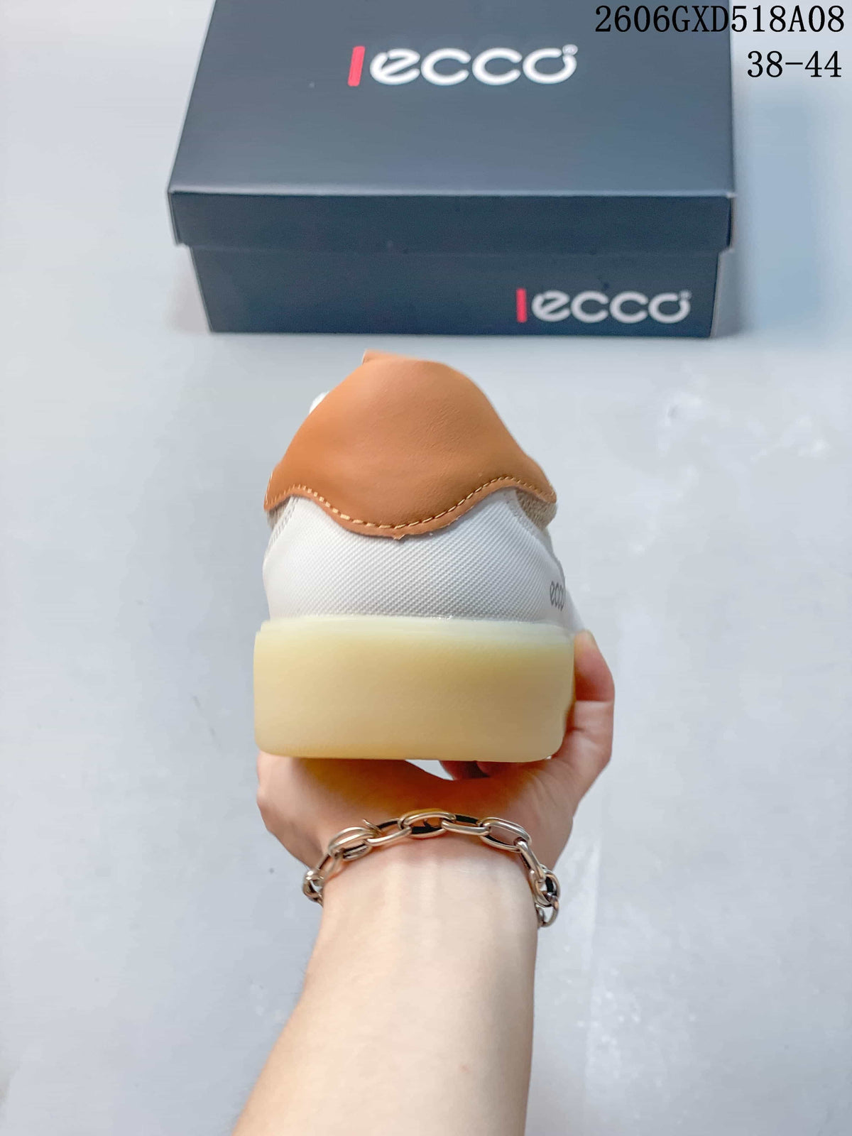Rear view of a sneaker with a tan heel accent and light-colored sole.