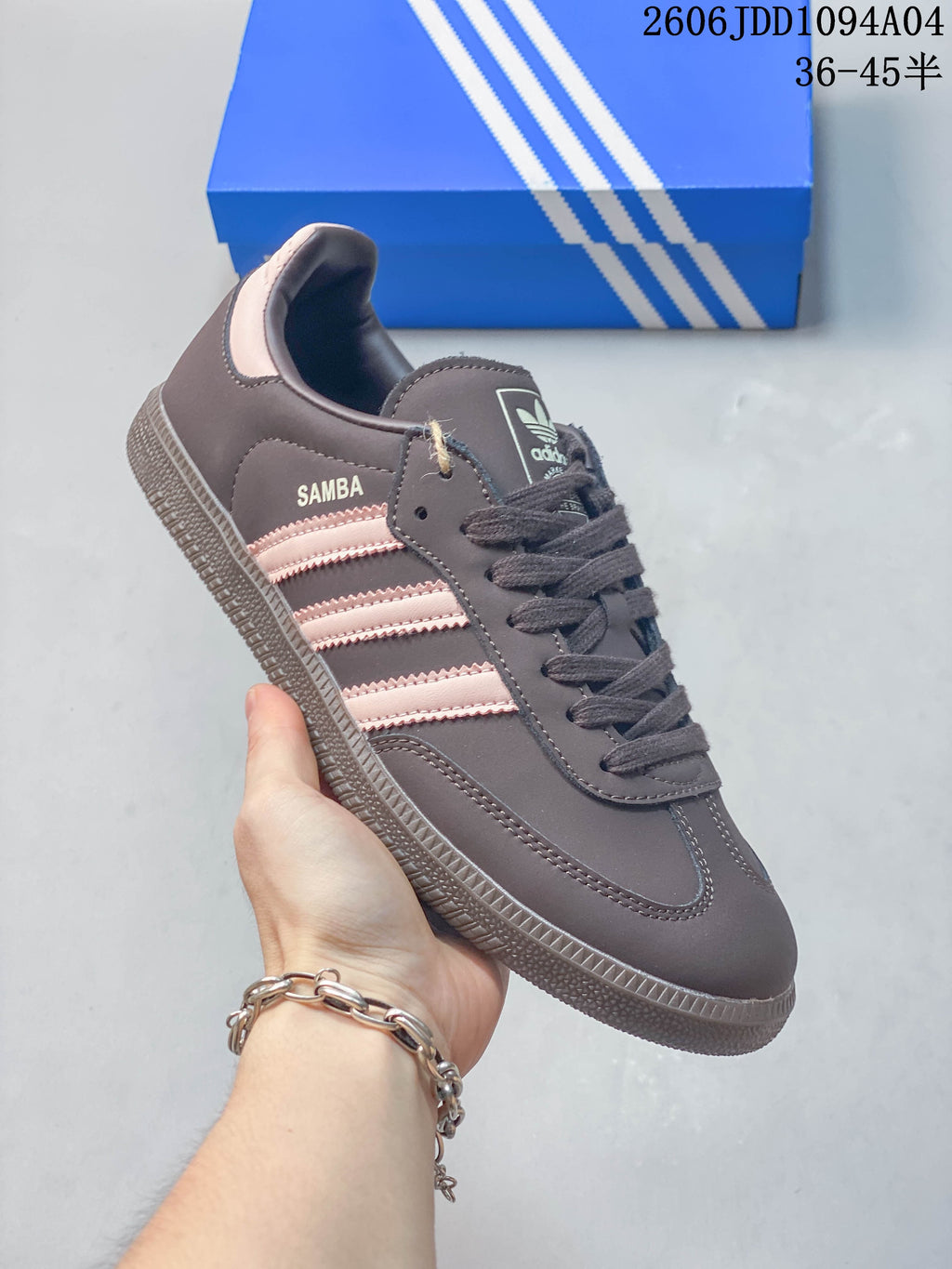Angled side view of the Adidas Samba OG sneaker with pale pink stripes and visible Samba lettering