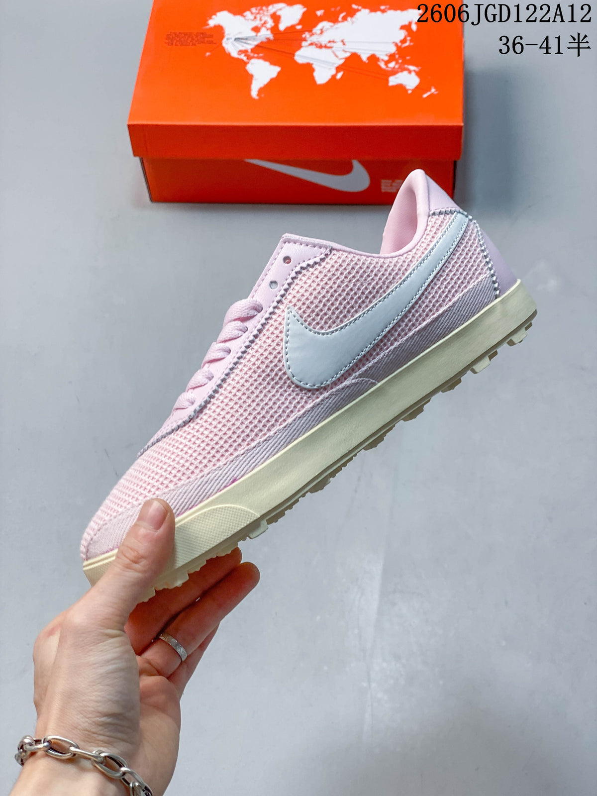 Side profile showing the pink textured upper and white swoosh