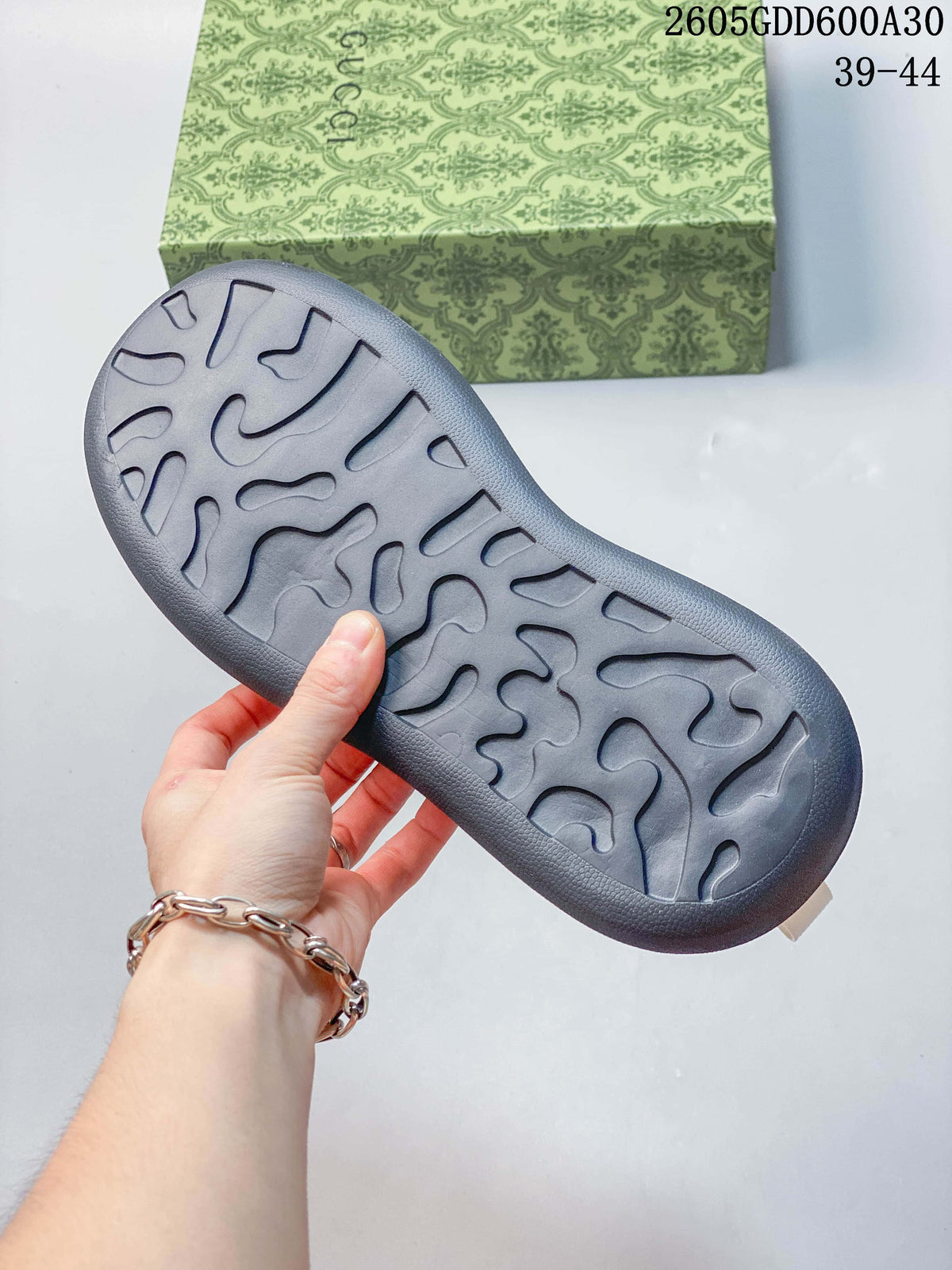 Underside of the sneaker showing its dark outsole and tread pattern.