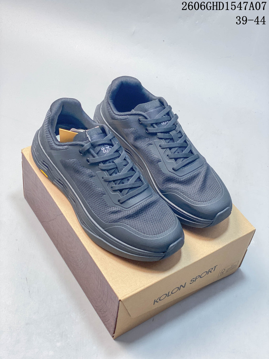 Pair of dark gray Kolon Sport low-top sneakers shown on a branded box
