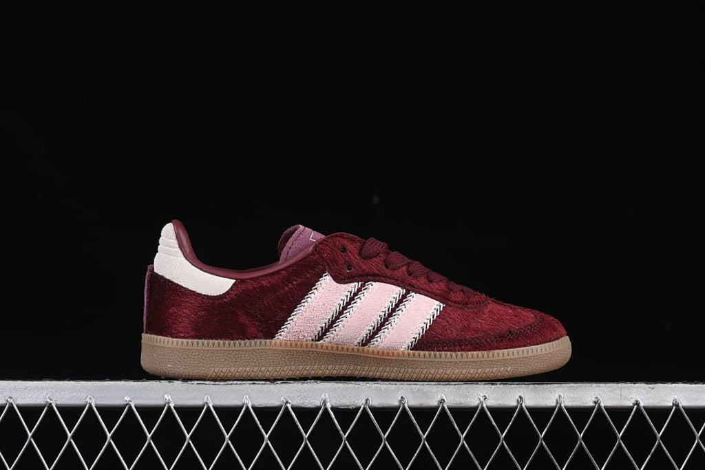 Side profile of a burgundy sneaker with pale pink stripes and gum-colored sole